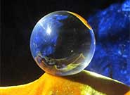 photo-realistic image of a crystal ball on top of golden-yellow velour-like fabric against a deep blue background.