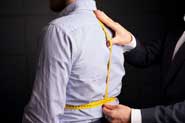 photo of a tailor taking measurements of a client