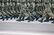 Soldiers' legs and boots marching in camouflage uniform